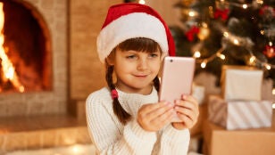 Ni&ntilde;a con un m&oacute;vil en Navidad