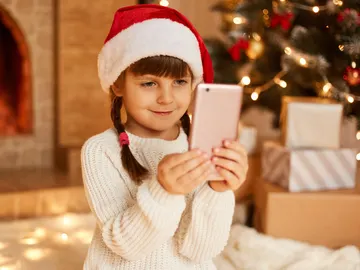Niña con un móvil en Navidad Niña con un móvil en Navidad