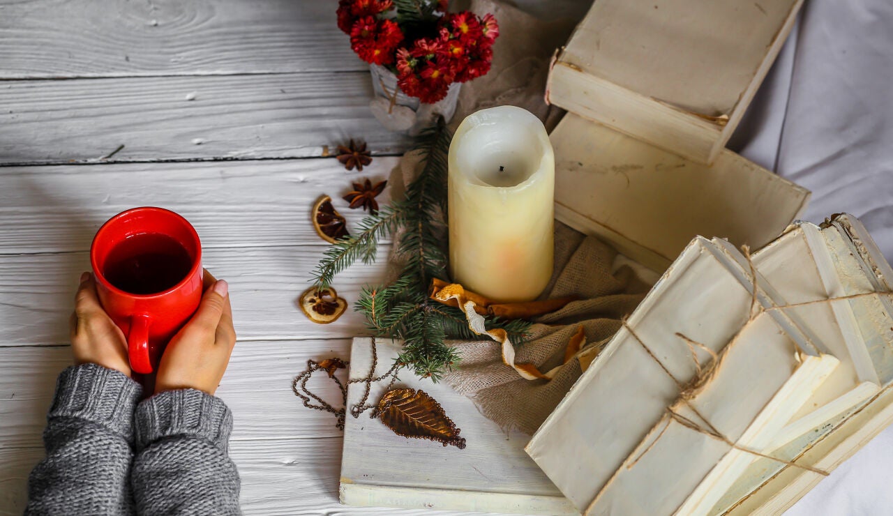 Una bebida caliente, una vela y unos papeles