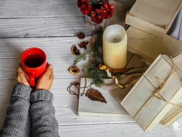 Una bebida caliente, una vela y unos papeles Una bebida caliente, una vela y unos papeles