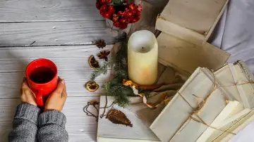 Una bebida caliente, una vela y unos papeles Una bebida caliente, una vela y unos papeles