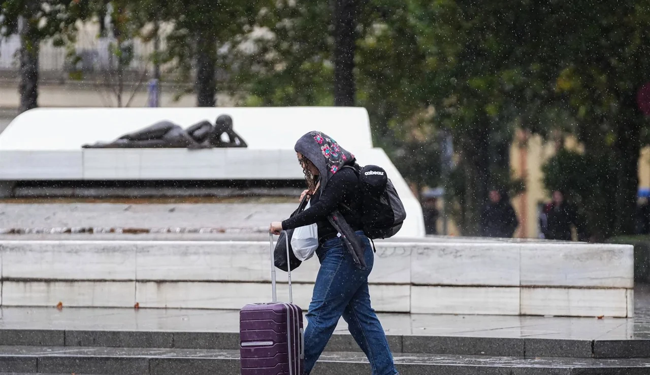 Imagen de archivo de una mujer caminando bajo la lluvia.