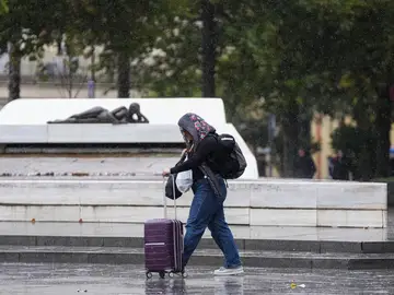 Imagen de archivo de una mujer caminando bajo la lluvia. Imagen de archivo de una mujer caminando bajo la lluvia.
