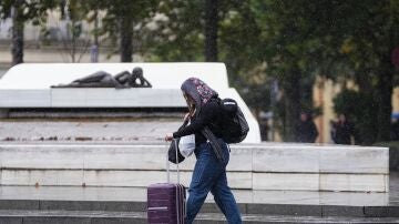 Imagen de archivo de una mujer caminando bajo la lluvia.