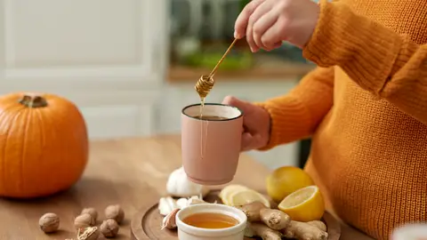 Una mujer se hace una infusión con miel Una mujer se hace una infusión con miel