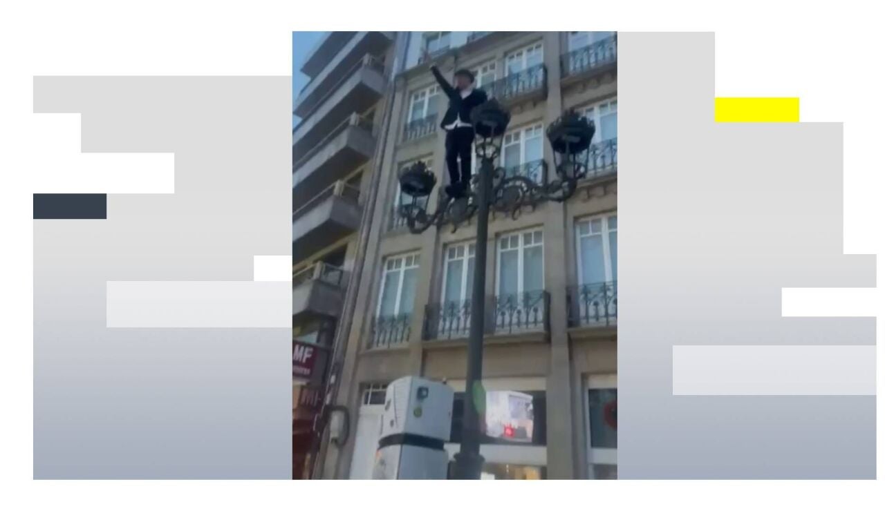 Un joven en una farola en Santiago de Compostela