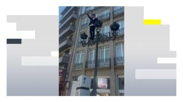 Un joven en una farola en Santiago de Compostela