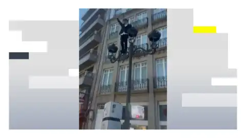 Un joven en una farola en Santiago de Compostela santiagook (1)