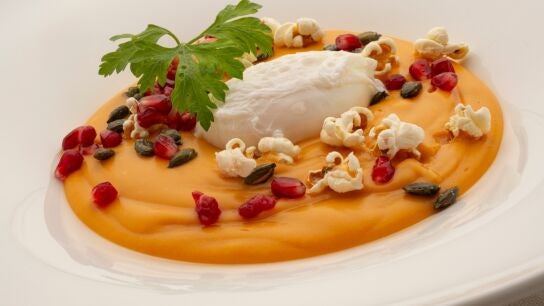 Crema de boniato con huevo poch&eacute;, granada y palomitas