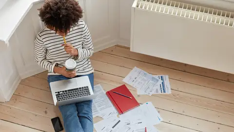 Mujer teletrabajando cerca del calentador Mujer teletrabajando cerca del calentador