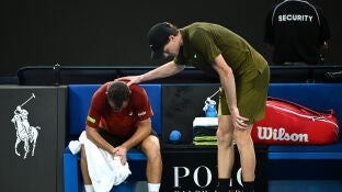 Jannik Sinner consuela a Hugo Gaston tras su retirada en el Open de Australia
