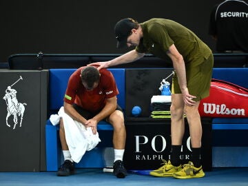Jannik Sinner consuela a Hugo Gaston tras su retirada en el Open de Australia