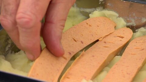 Abre las salchichas a lo largo por la mitad y distribúyelas sobre el puré