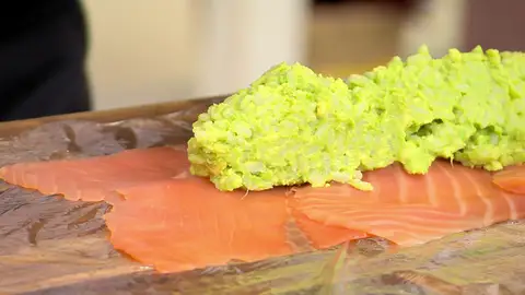 Reparte la mitad de la mezcla de aguacate y arroz a lo largo del salmón Reparte la mitad de la mezcla de aguacate y arroz a lo largo del salmón