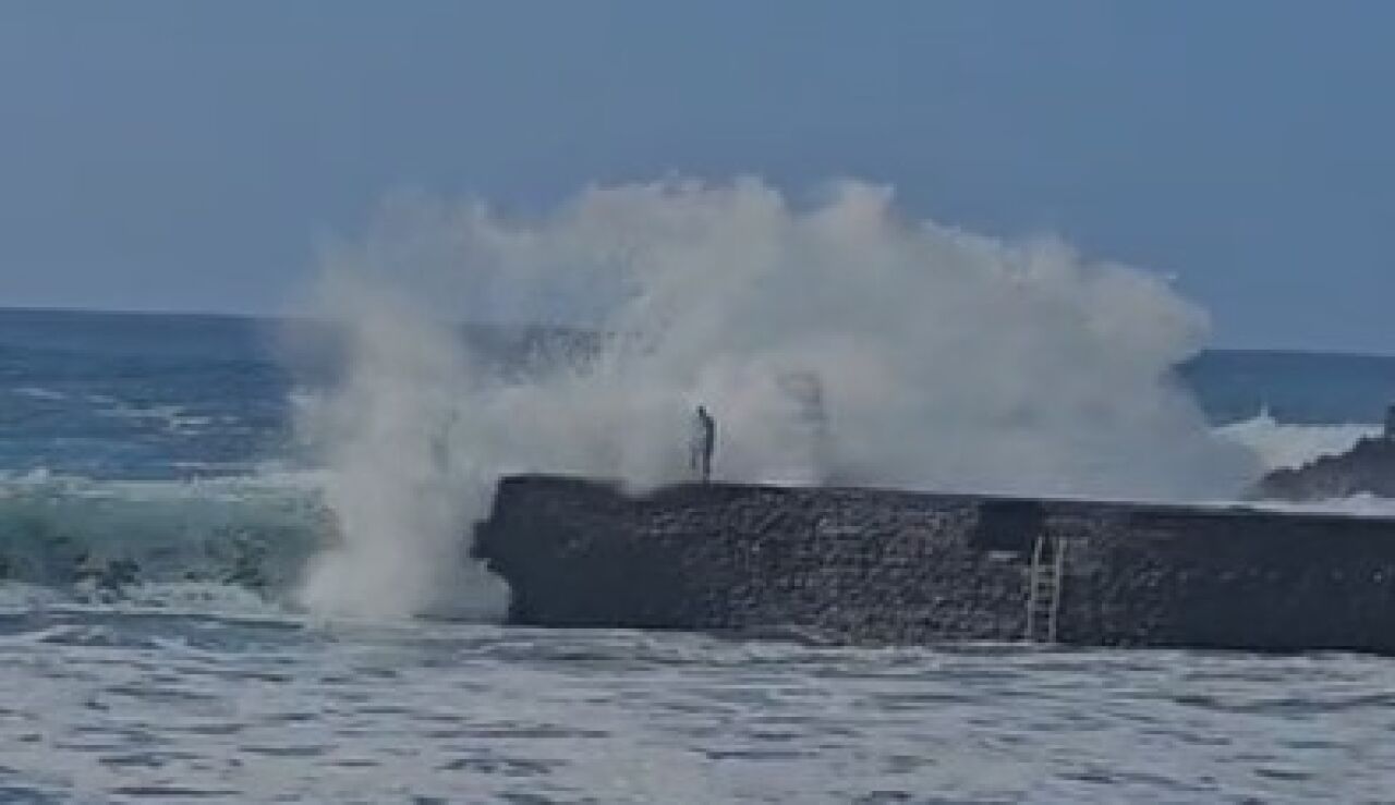 El momento en que la ola impacta con el hombre