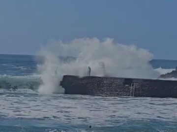 El momento en que la ola impacta con el hombre