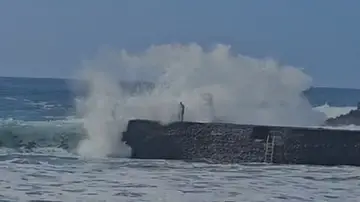 El momento en que la ola impacta con el hombre El momento en que la ola impacta con el hombre