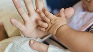 Imagen de archivo de la mano de una mujer y de un beb&eacute;.