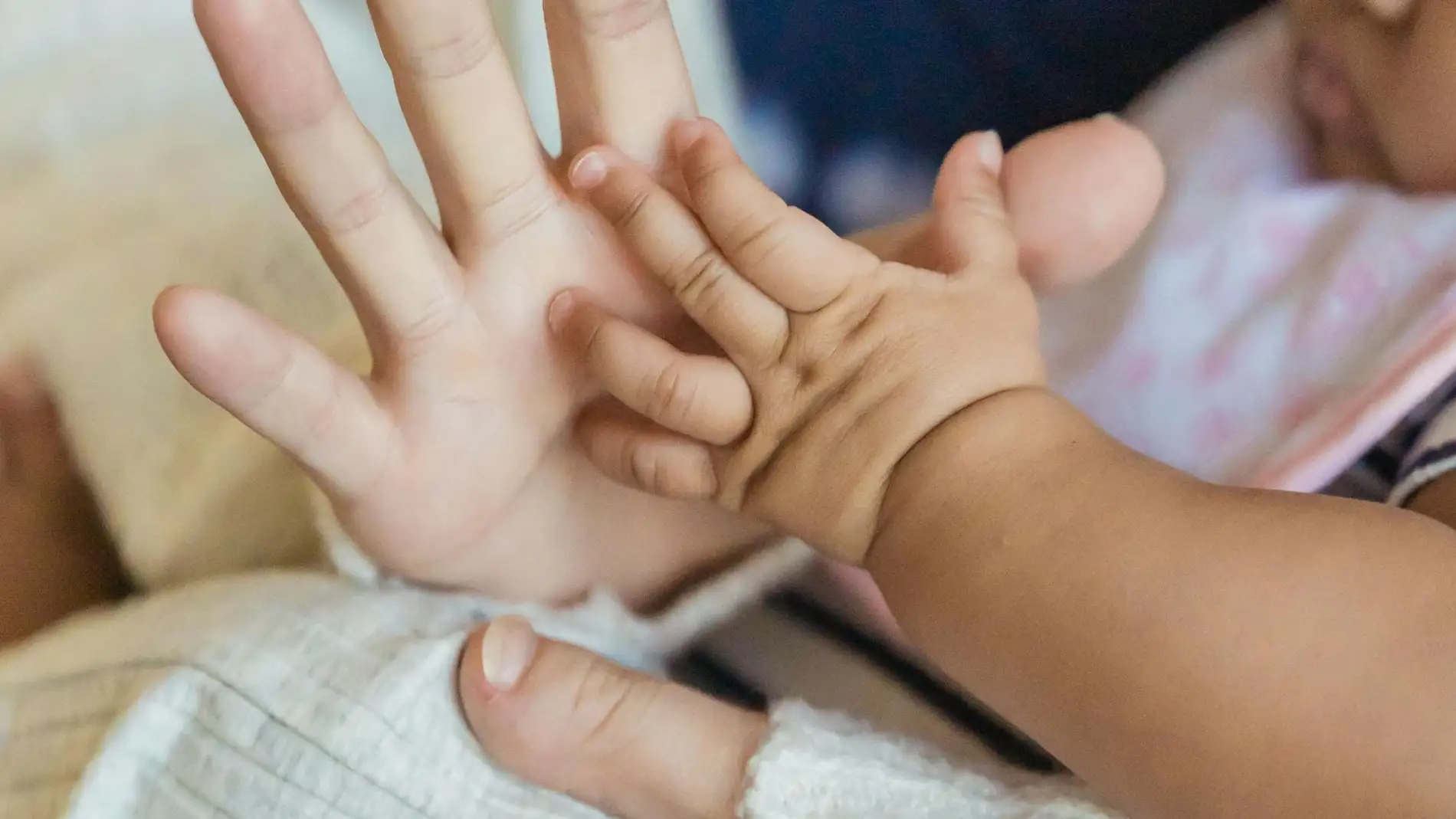 Imagen de archivo de la mano de una mujer y de un bebé. Imagen de archivo de la mano de una mujer y de un bebé.