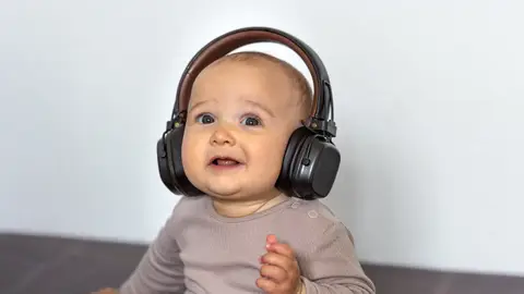 Un bebé con auriculares Un bebé con auriculares