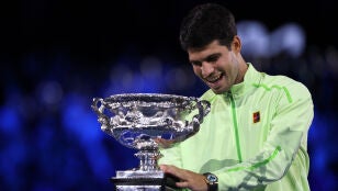 Carlos Alcaraz sonr&iacute;e ante el trofeo del Open de Australia
