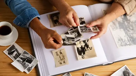 Pareja mirando fotos antiguas de un álbum Pareja mirando fotos antiguas de un álbum