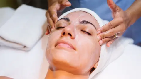 Una mujer haciéndose un tratamiento facial Una mujer haciéndose un tratamiento facial