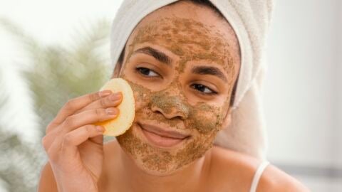 Mujer exfoliándose la piel de la cara