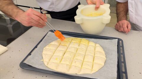 Con un pincel, unta la masa con la crema de ajo