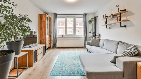 Salón de un piso con muebles de madera y plantas naturales Salón de un piso con muebles de madera y plantas naturales