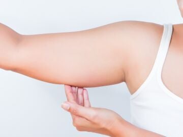 Mujer toc&aacute;ndose el brazo