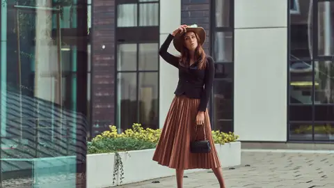 Modelo viste falda marrón y chaqueta negra Modelo viste falda marrón y chaqueta negra