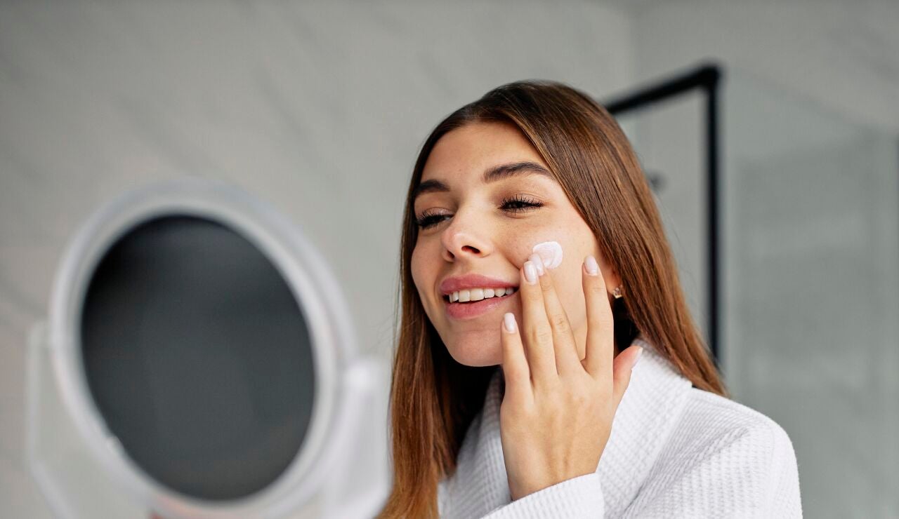 Mujer aplic&aacute;ndose crema en la cara