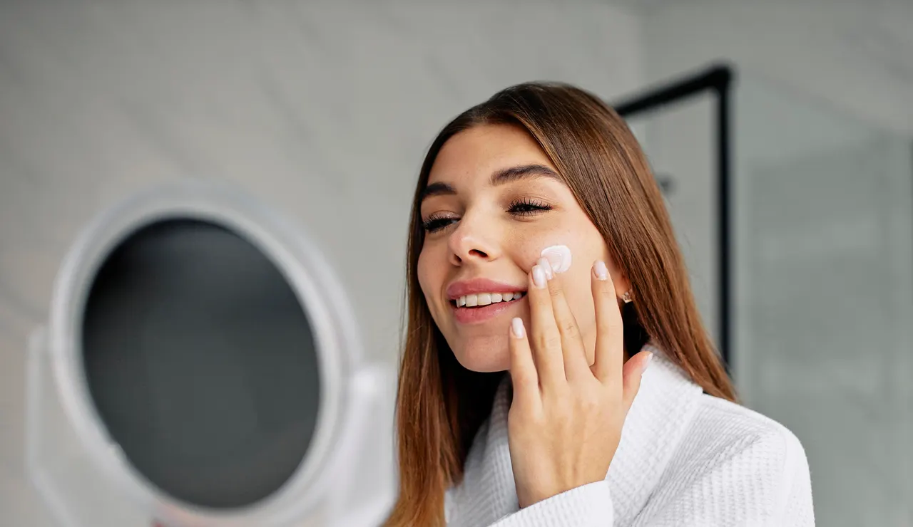 Mujer aplicándose crema en la cara