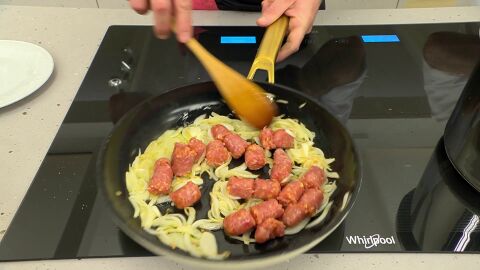 Corta las salchichas en trozos de bocado, introdúcelas en la sartén