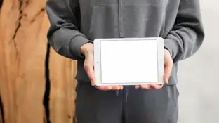 Un joven sosteniendo un Ipad Un joven sosteniendo un Ipad