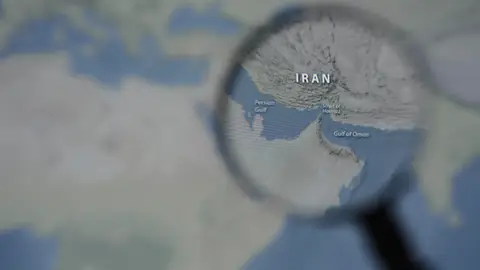 Parlamentarios de Irán proponen imponer el pago de tasas a los buques que pasen por el estrecho de Ormuz March 13, 2026, Taichung, Taiwan: A magnified image of a map through a handheld magnifying glass depicts the Persian Gulf, Iran, the Strait of Hormuz and the Gulf of Oman. Europa Press/Contacto/Andre M. Chang 13/03/2026 ONLY FOR USE IN SPAIN