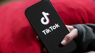 Jóven abriendo TikTok en el teléfono móvil.
