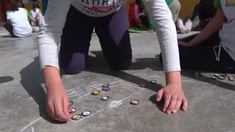 El fútbol chapas ha vuelto al patio de un colegio sevillano, los alumnos han aprendido a jugar y se ganan las chapas por su buen comportamiento El fútbol chapas ha vuelto al patio de un colegio sevillano, los alumnos han aprendido a jugar y se ganan las chapas por su buen comportamiento