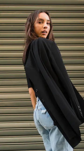 Joven con una americana negra y vaqueros Joven con una americana negra y vaqueros