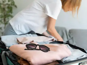 Mujer poniendo ropa en la maleta Mujer poniendo ropa en la maleta