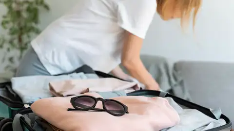 Mujer poniendo ropa en la maleta Mujer poniendo ropa en la maleta