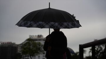 Peatones se protegen de la lluvia bajo sus paraguas.