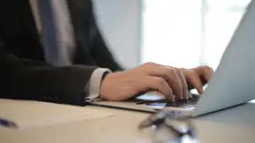 Una persona utilizando un ordenador portátil Una persona utilizando un ordenador portátil