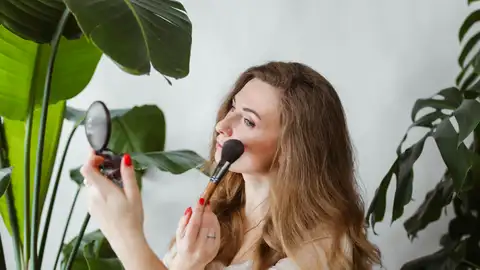 Mujer aplicándose blush Mujer aplicándose blush