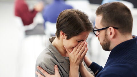 Mujer llorando y hombre consolándola