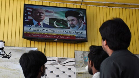 Varias personas miran hacia una pantalla de televisi&oacute;n con el presidente estadounidense Donald Trump y el l&iacute;der supremo iran&iacute; Mojtaba Jamenei, en Islamabad, Pakist&aacute;n, el 10 de abril de 2026
