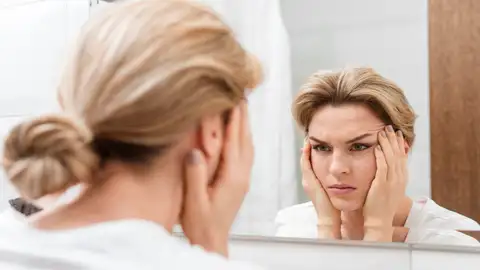 Mujer mirándose las arrugas Mujer mirándose las arrugas