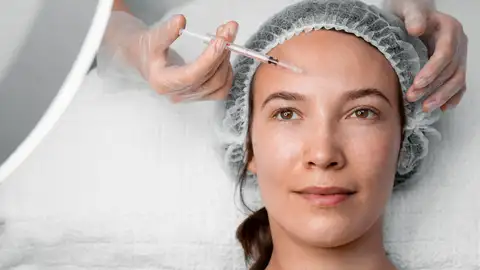 Mujer realizándose un retoque estético Mujer realizándose un retoque estético