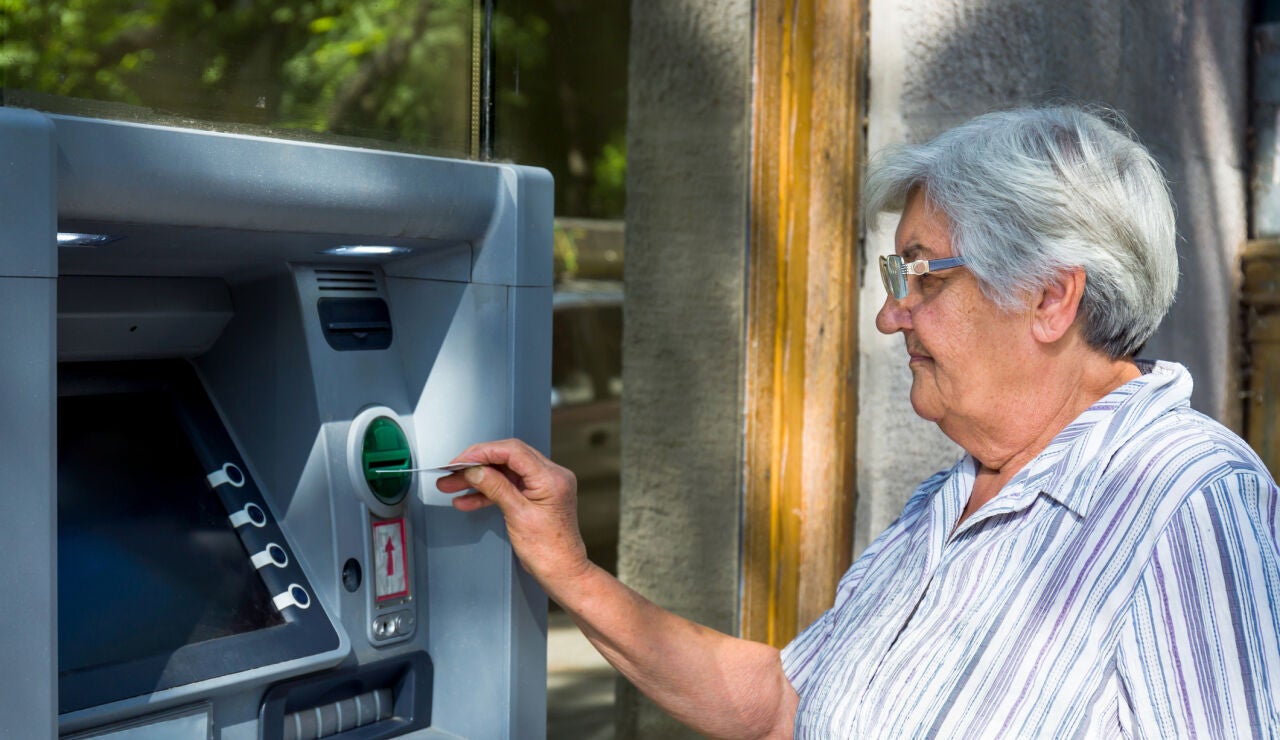 Mujer mayor sacando dinero del cajero